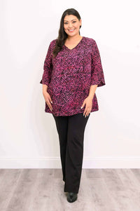 Front view of woman in Evelyn Top with pink botanical pattern and black pants