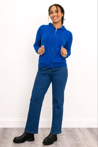 Full body front view of woman in a cobalt blue cashmere hoodie with straight leg jeans