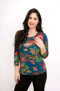 Woman wearing fitted blue bamboo tee with colorful floral botanical print, front half-length view