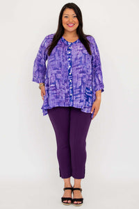 Front view of model in purple tunic top and pants, hands by sides