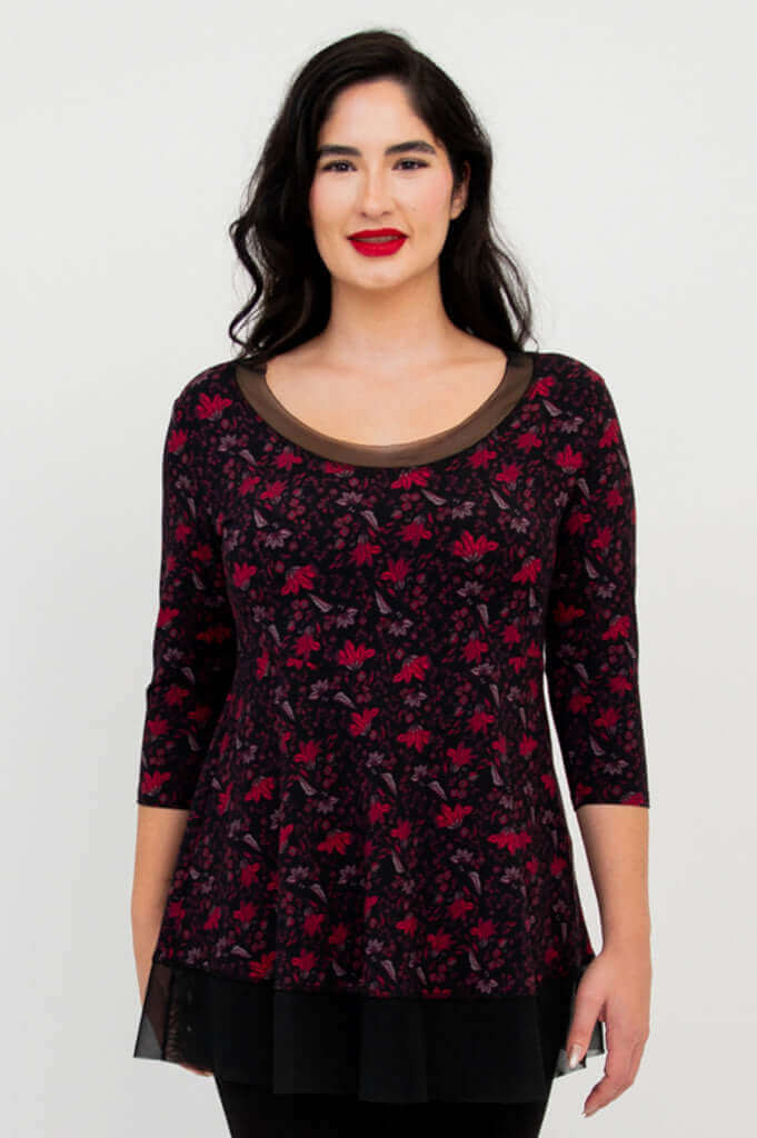 Front close-up of woman in floral mesh tunic top with black trim and hem