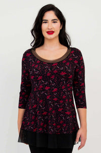 Front close-up of woman in floral mesh tunic top with black trim and hem