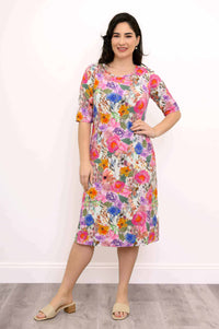 Woman modeling floral print bamboo dress with hands on hips, front view