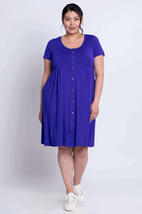 Front profile of a woman in a knee-length cobalt blue button dress