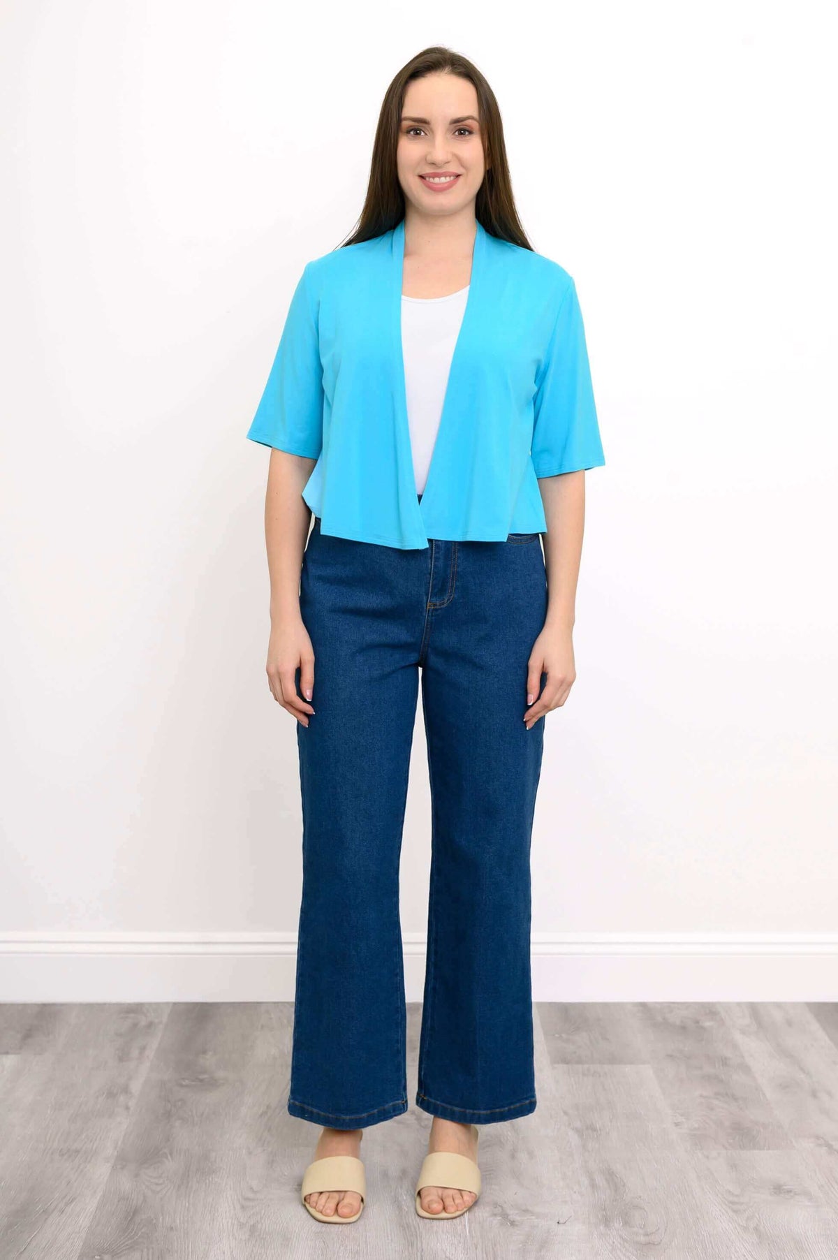 Front view of model standing in blue cropped bamboo jacket and jeans