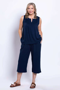 Front view of a woman wearing navy linen capri pants and a sleeveless top