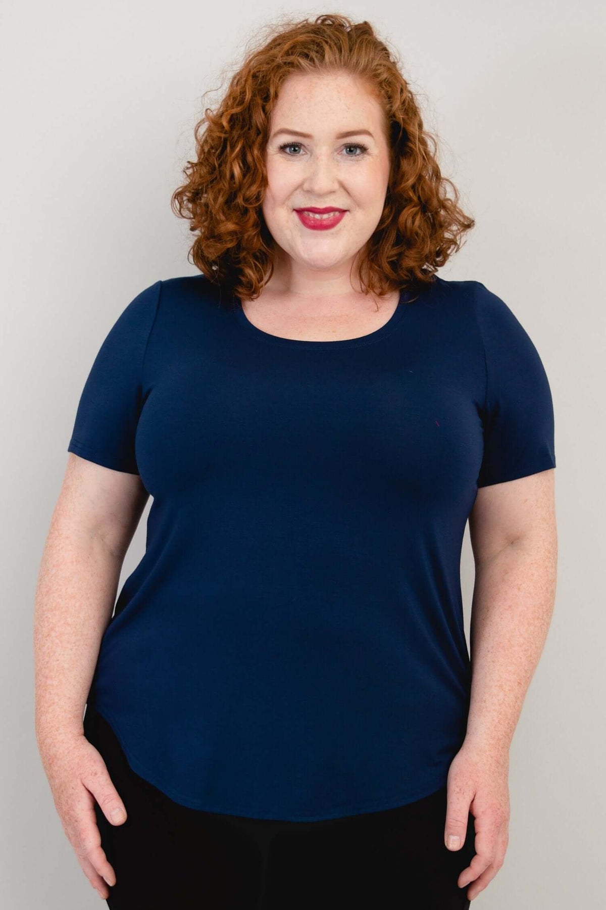 Front view of model wearing a navy blue scoop neck short sleeve tee