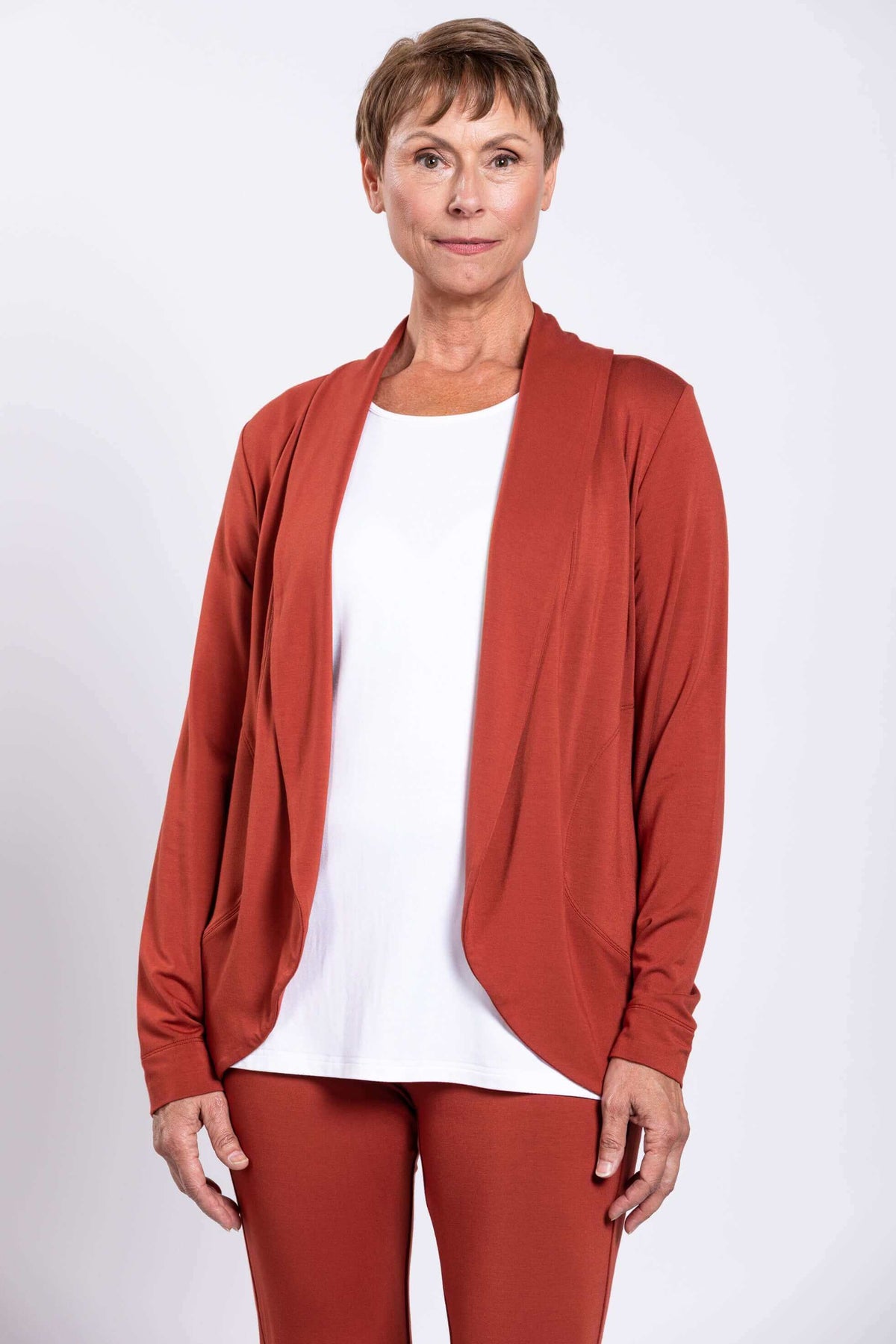 Front view of woman wearing a rust-colored French Terry jacket over a white top