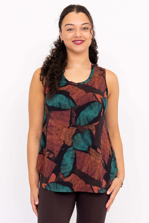 Front view of model wearing sleeveless top with autumn leaf print