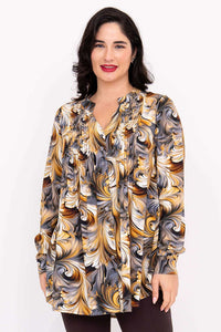 Front view of woman wearing swirl blouse with gold, grey, and white print