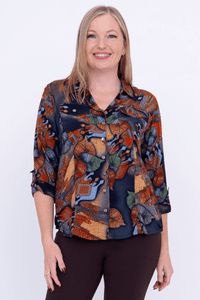 Front view of woman wearing a botanical print button-up blouse with collar and tabbed sleeves