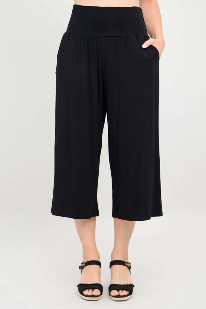 Front view of black Gaylene capri pants with hand in pocket
