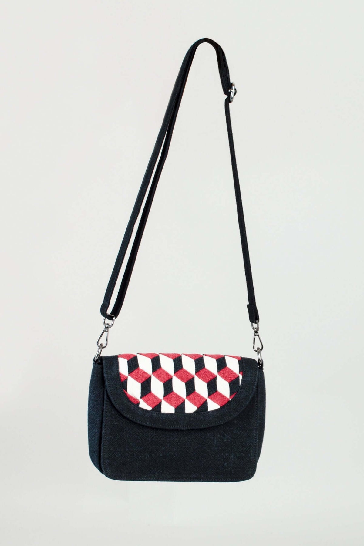 Front view of black crossbody bag with geometric embroidered flap