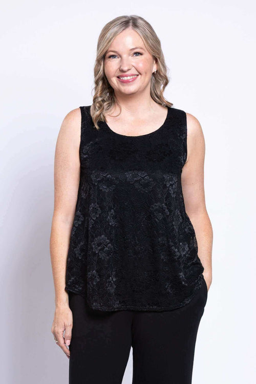 Front view of woman wearing black sleeveless lace tank top and black pants
