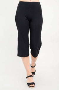 Front view of a woman wearing black yoga capri pants and black heeled sandals