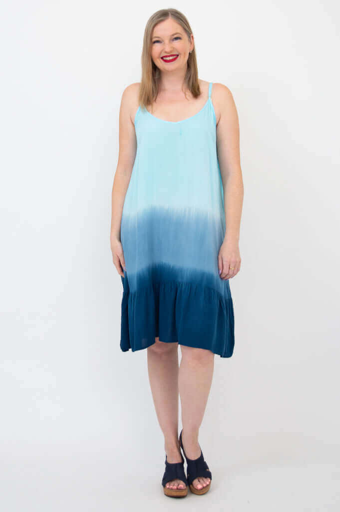 Front view of woman wearing a sleeveless blue ombre knee-length tiered dress
