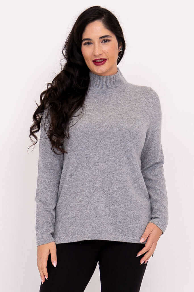Front view of model wearing light grey mock neck sweater with long sleeves
