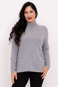 Front view of model wearing light grey mock neck sweater with long sleeves