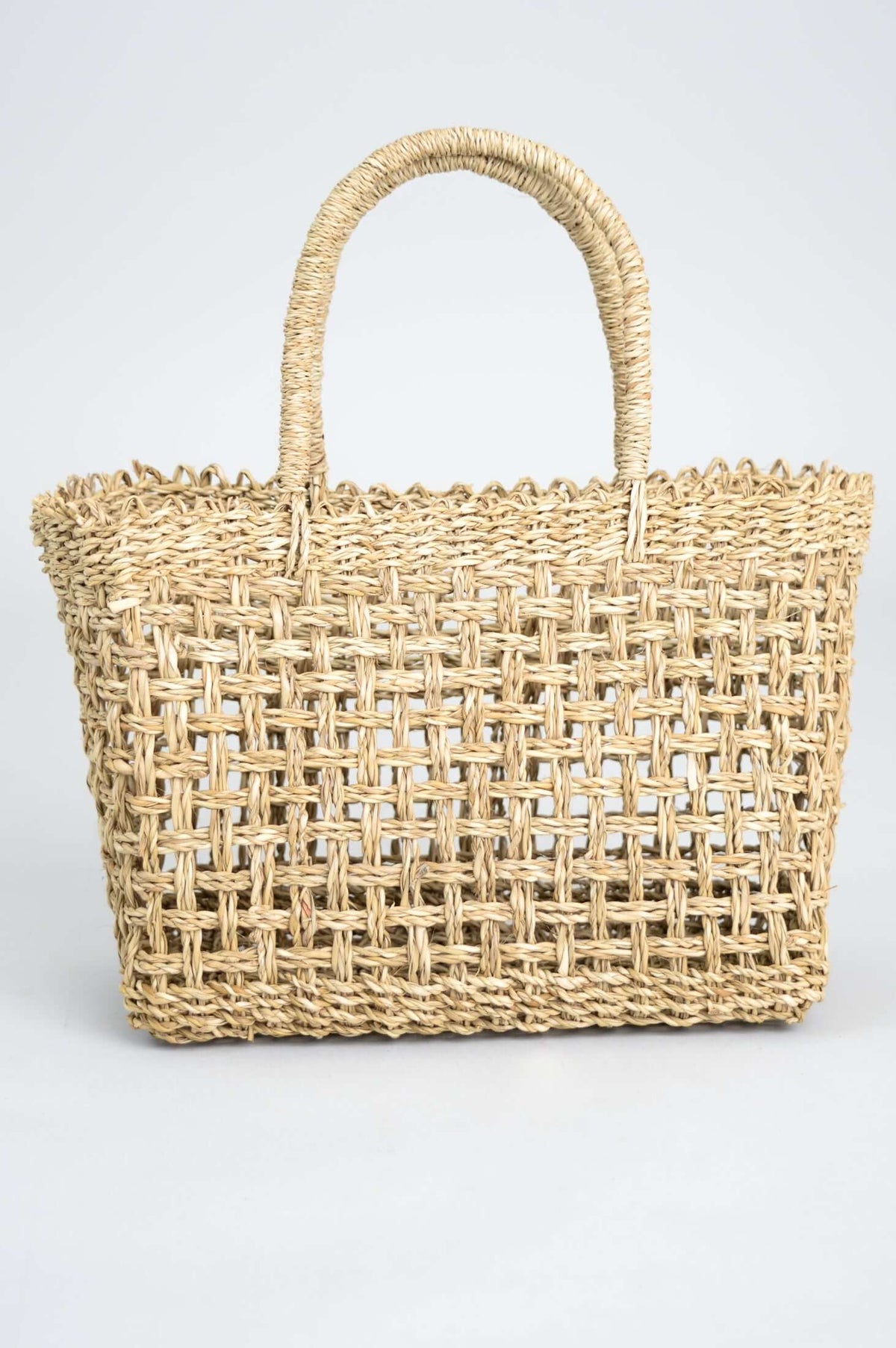 Front view of a hand woven rattan basket with two handles