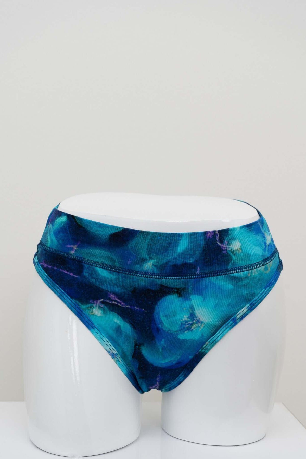 Front view of high rise blue watercolor bamboo thong on a mannequin