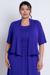 Front view of model wearing a vibrant cobalt blue cropped jacket over a matching dress