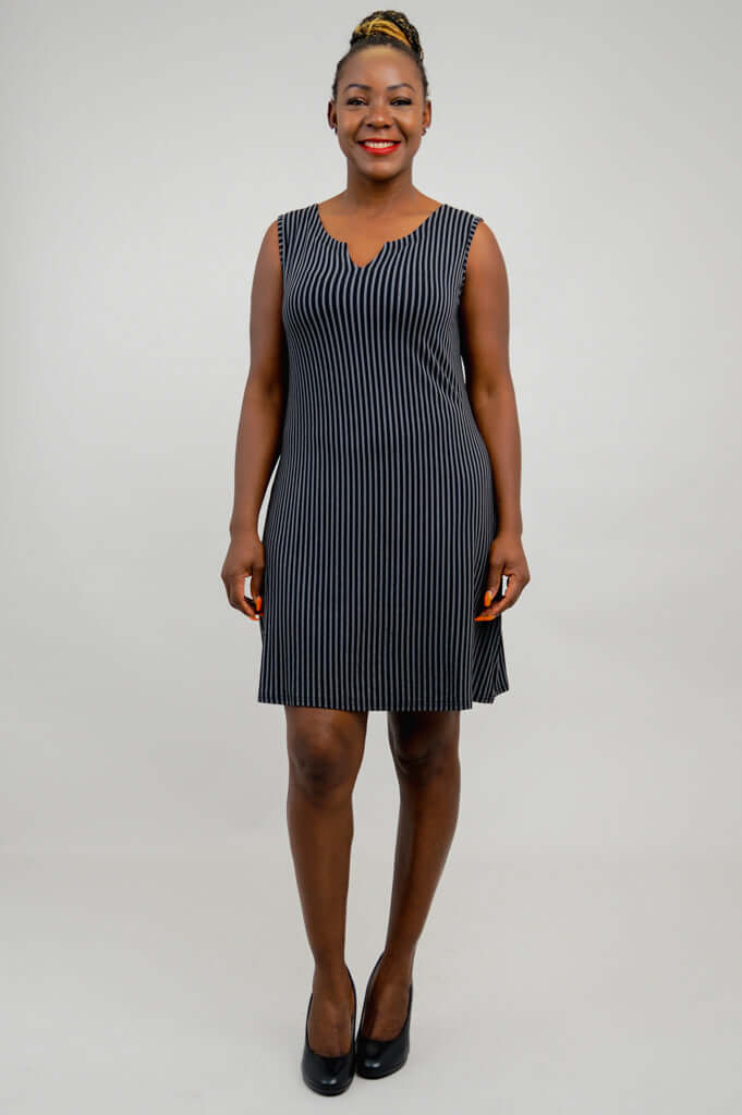 Front view of woman wearing sleeveless black and white pinstripe shift dress