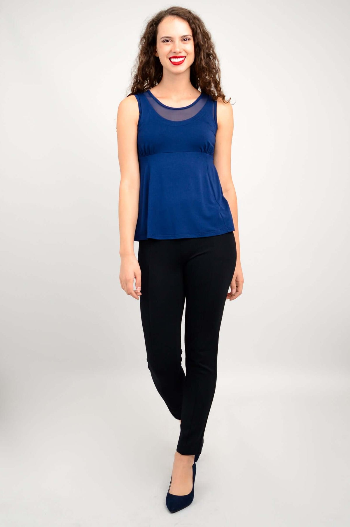 Woman standing in front view wearing navy sleeveless tank top with mesh yoke