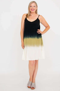 Front view of woman wearing black to olive ombre knee-length dress with spaghetti straps