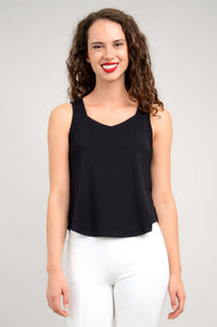 Front view of a woman wearing a sleeveless black tank top and white pants