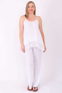 Full-length view of a woman in a white lace tank top and white pants