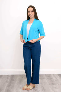Full-body view of model in bright blue cropped jacket, white shirt, and blue jeans