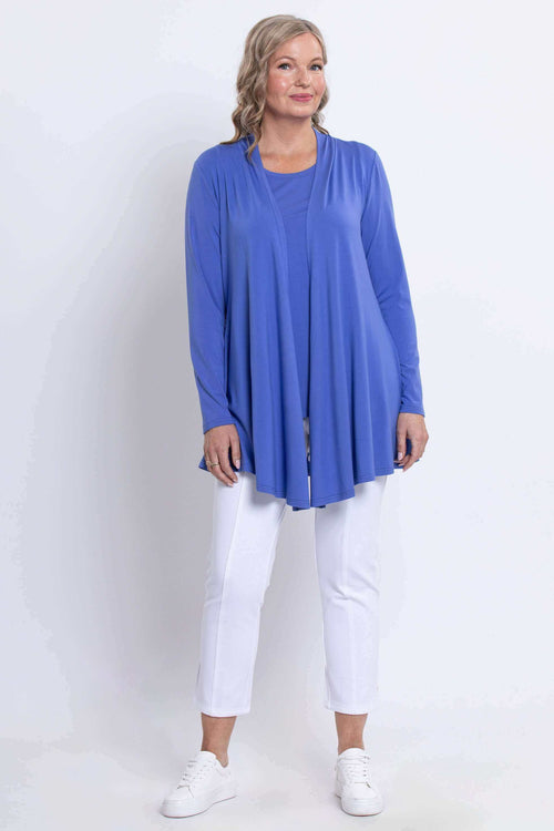 Full body view of model in blue bamboo light jacket and white pants against a white background