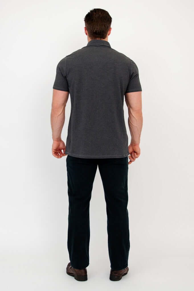 Full back view of man in a dark grey bamboo polo shirt and dark pants
