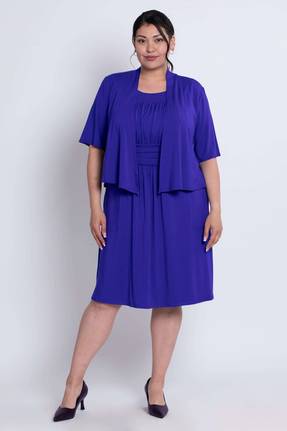 Full body front view of model in cobalt blue short sleeve cropped jacket and dress