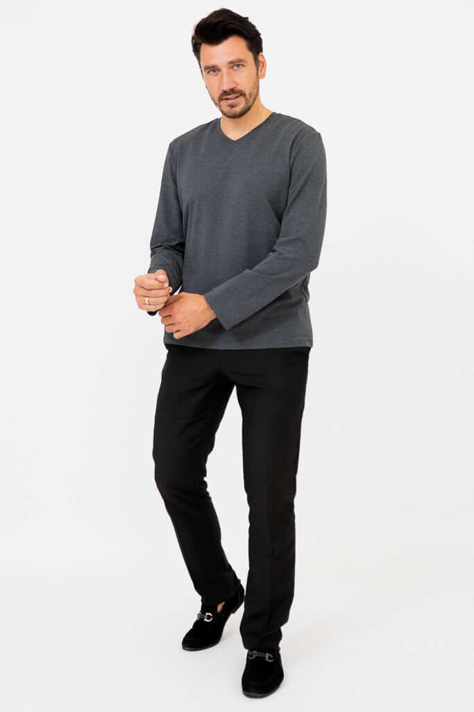 Man in charcoal V-neck long sleeve and black pants, full body front view