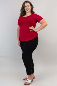 Woman in a crimson scoop neck tee and black pants, hand on hip, full body