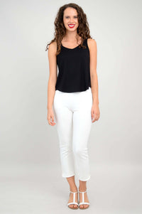 Full body view of a woman in a black tank top paired with white pants and sandals