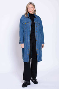 Full body view of a woman wearing a black inner outfit paired with a long blue denim duster coat.