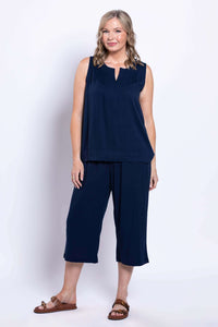 Full front view of a woman in navy linen capri pants and sleeveless top