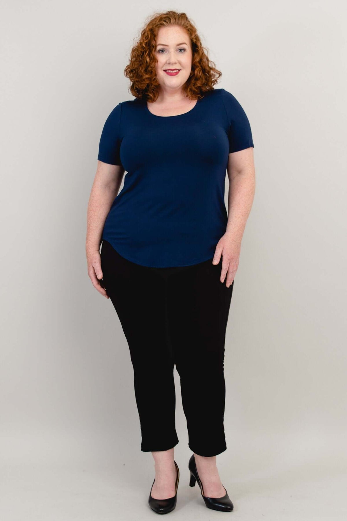 Full front pose of model wearing navy blue tee with black pants