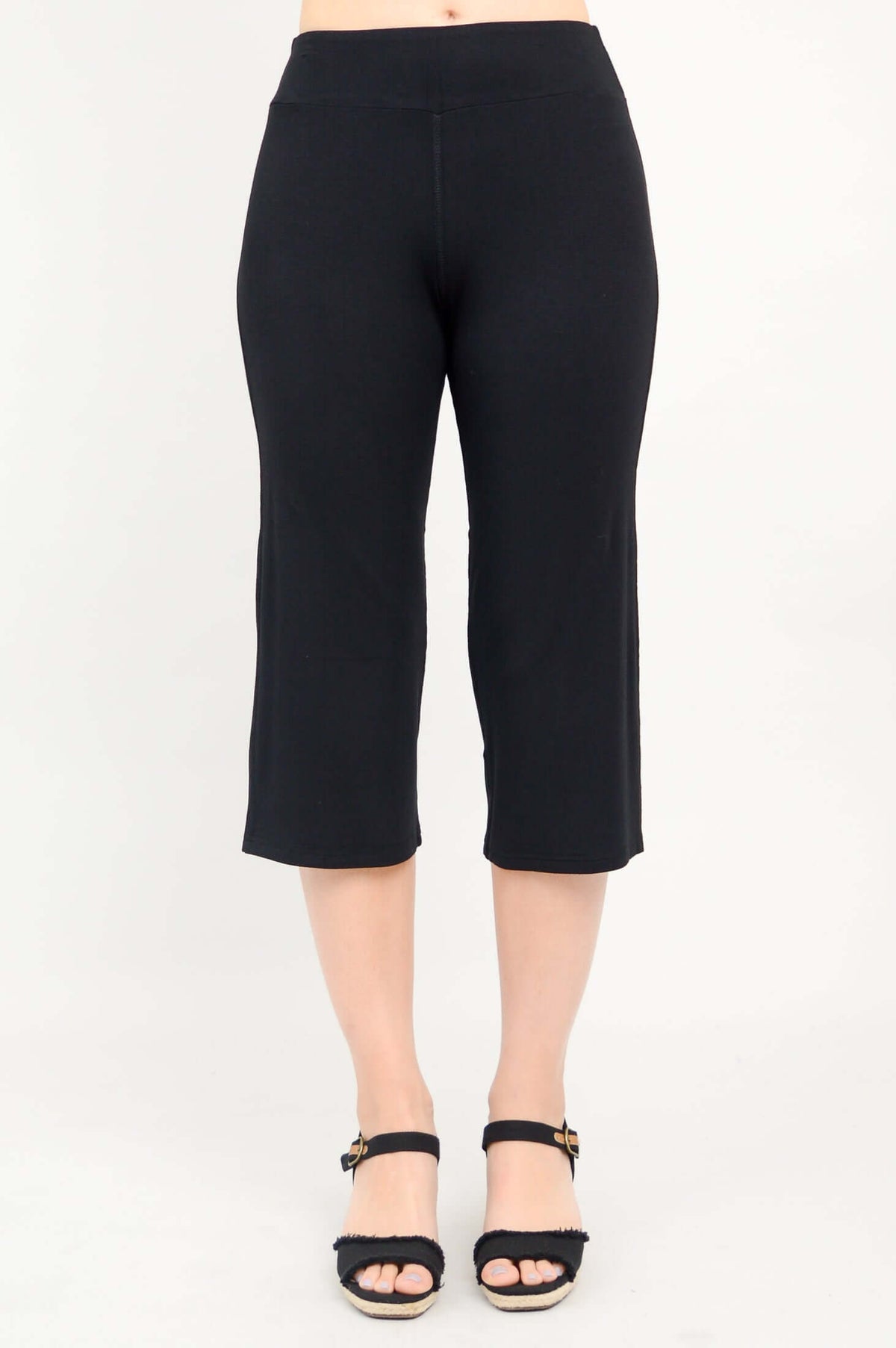 Full front view of black yoga capri pants on a woman with black sandals