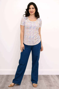 Woman in Tessa Tee with confetti dot pattern and blue jeans, standing full frontal view