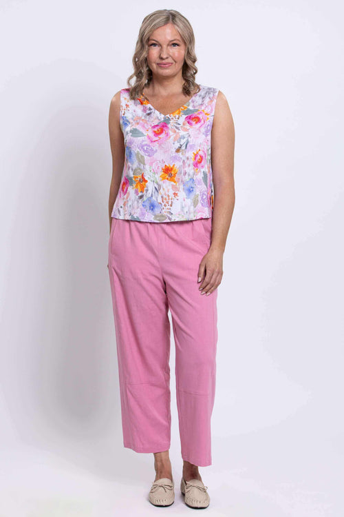 Full front view of woman in floral cropped tank and pink trousers
