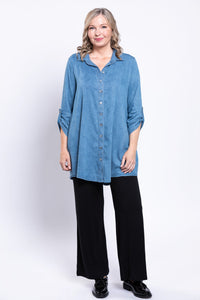 Full body front view of woman wearing tencel denim button up tunic and black loose-fit pants
