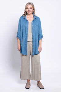 full body front view of woman wearing unbuttoned tencel denim shirt over a beige outfit