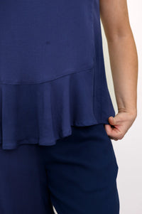 Front view of woman wearing a navy blue sleeveless top and navy blue pants on a white background
