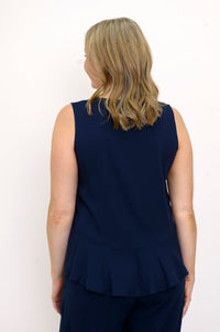 Back view of woman wearing a navy blue sleeveless top and navy blue pants on a white background