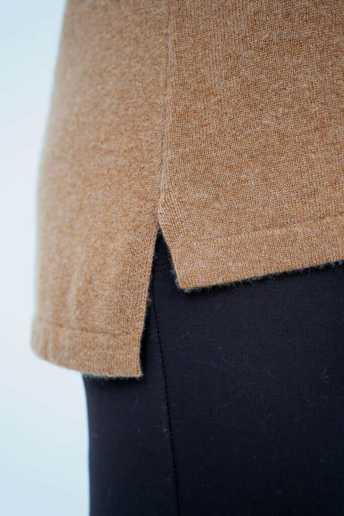 Close-up of the hi-lo hem detail on the camel brown sweater