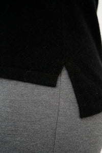 Close-up of hi-lo hemline detail on black sweater