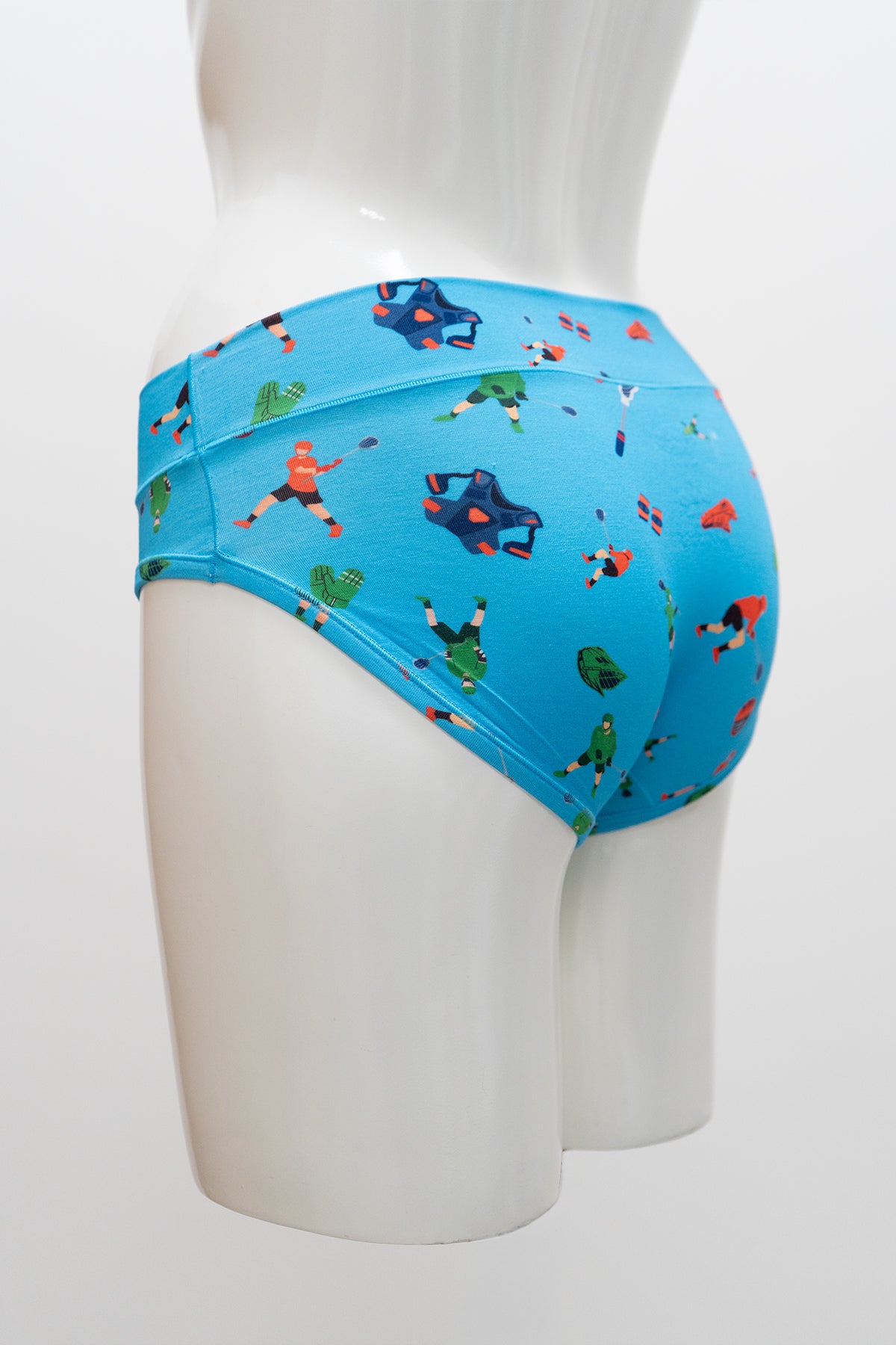 Blue underwear with a colorful lacross pattern on a mannequin against a white background, side view